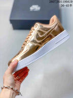Side view showing the metallic gold upper, Swoosh detail, tonal stitching and white platform-style sole.