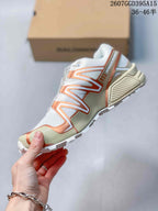 Side view showing the white mesh-style upper, bronze structural overlays, cream midsole and lugged outsole.