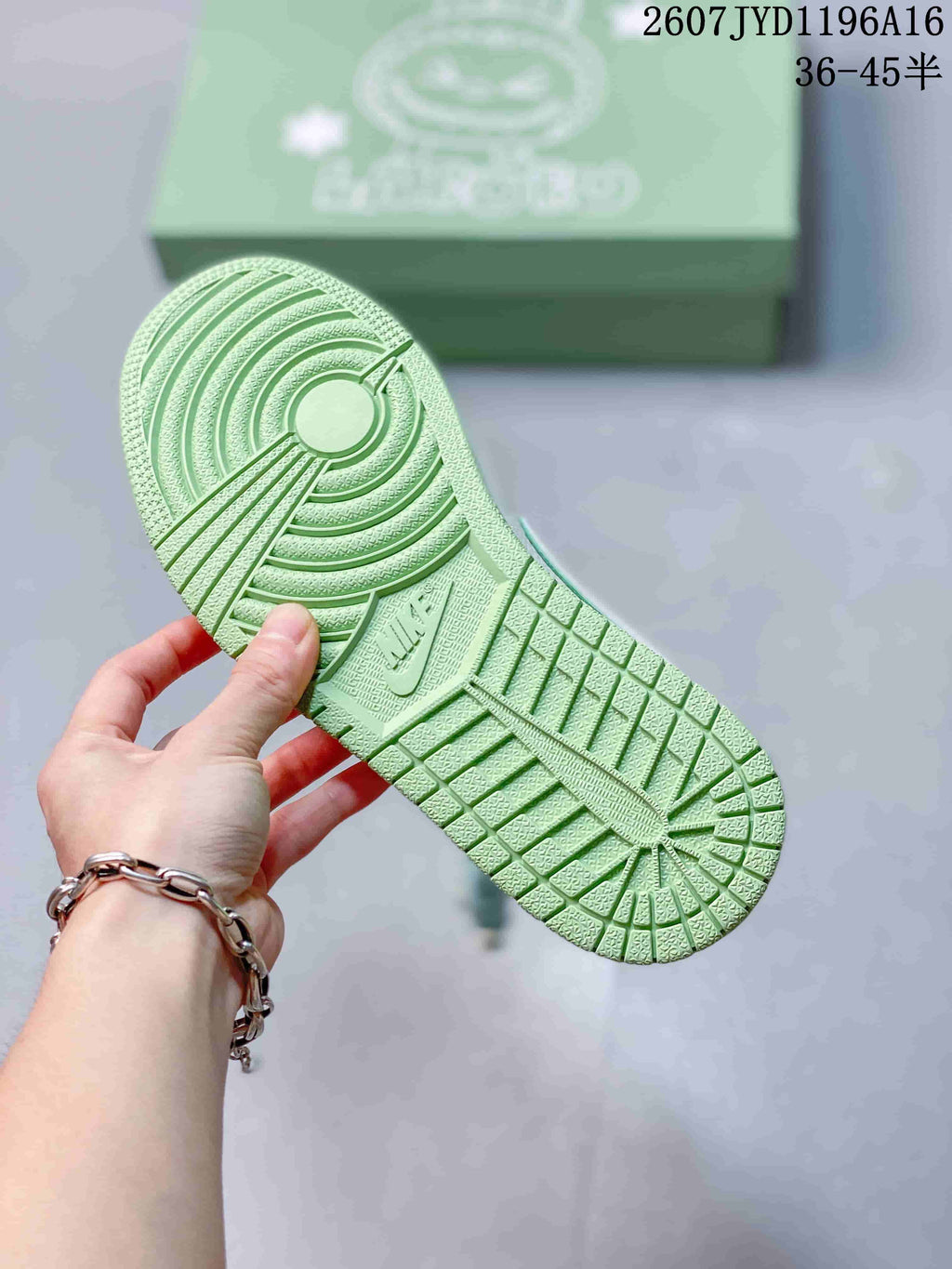 Green rubber outsole of the sneaker showing its circular and grid-pattern tread.