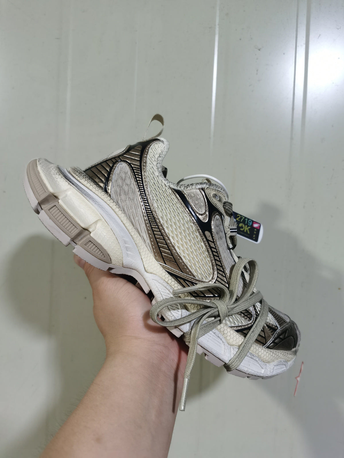 Close angled view showing the sneaker's layered upper, lace system, padded collar, and textured outsole.