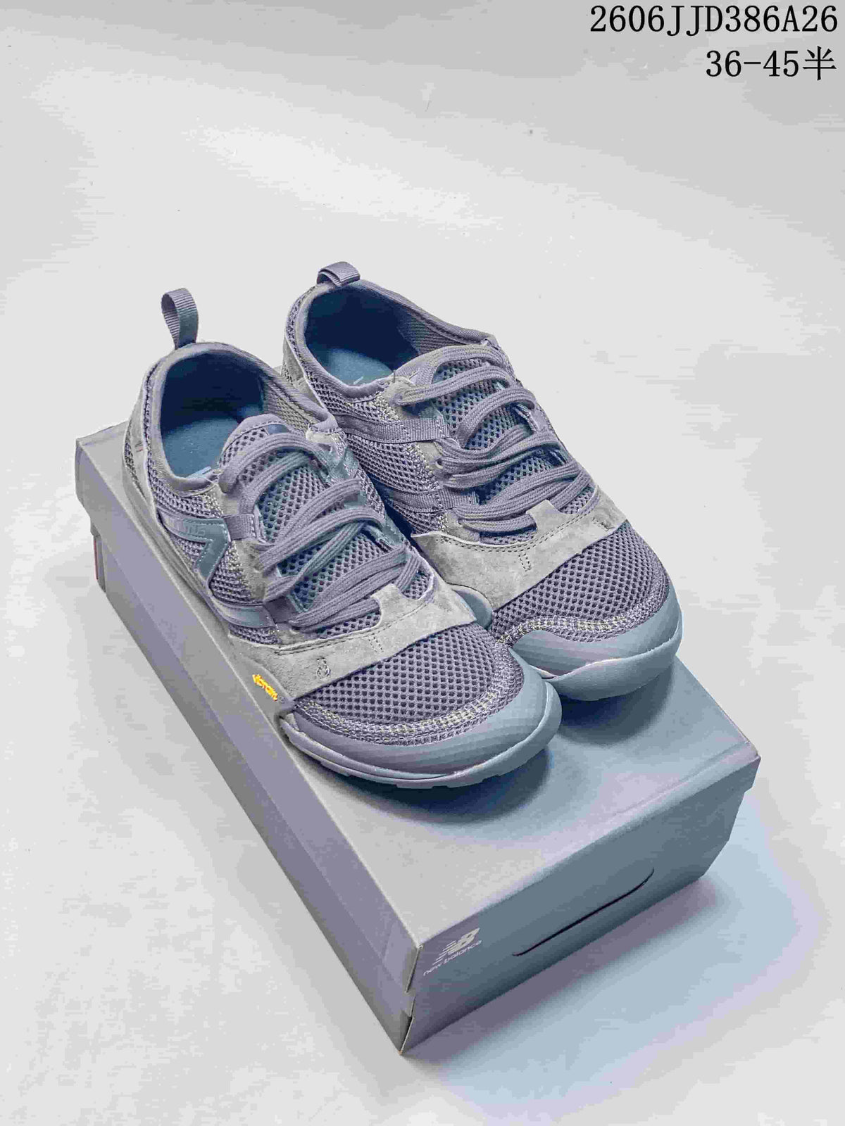 Grey New Balance MT10O sneakers displayed on a shoebox, showing the mesh upper, lace-up design, and style code JJD386A26.