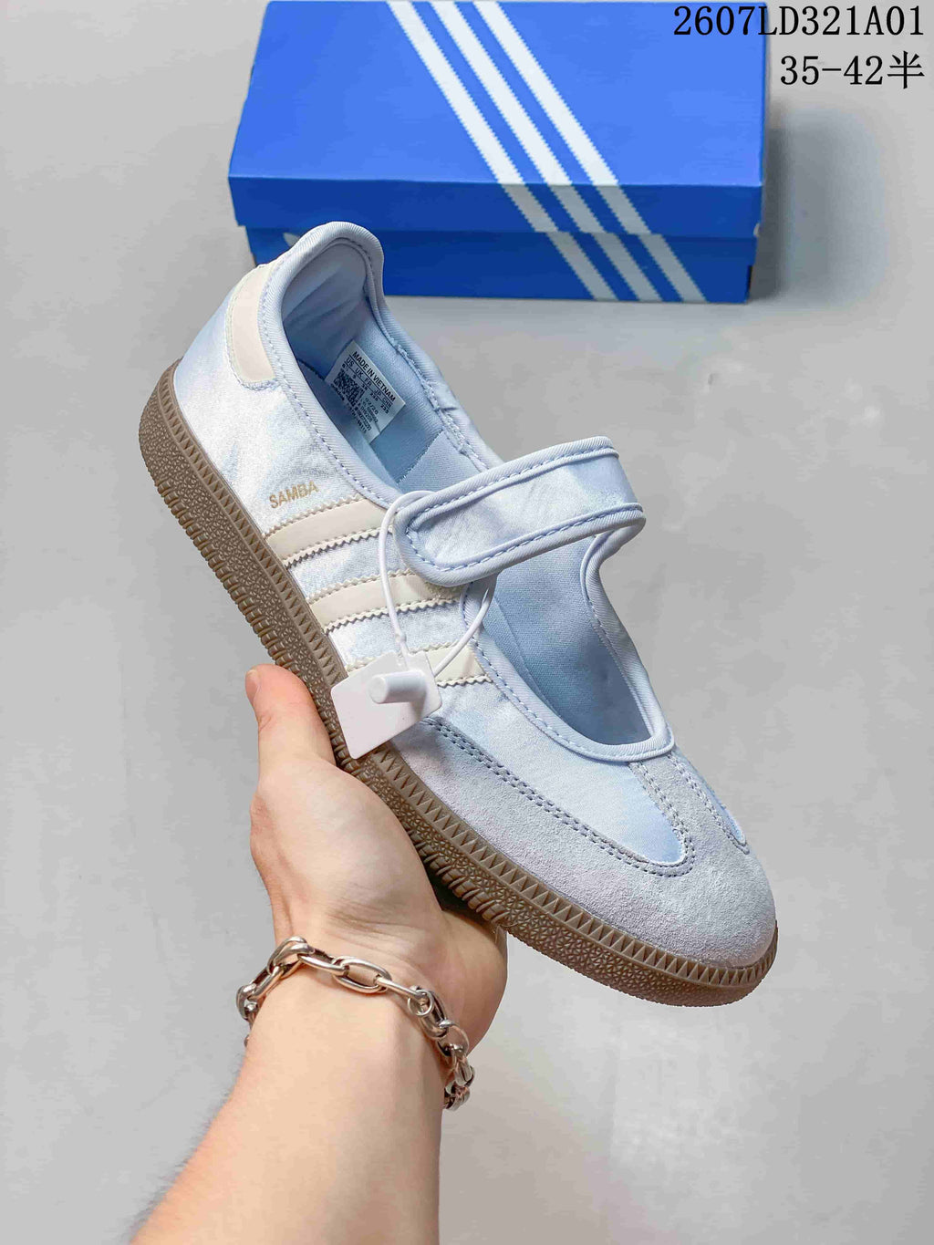 Side view of a pale blue Samba Jane sneaker showing its strap, three stripes, and gum-colored outsole.
