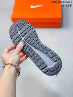 Close-up of the textured outsole showing segmented tread blocks and a central Nike-shaped detail, with an orange shoebox in the background.