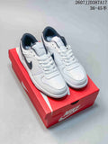 Pair of white and black Nike low-top sneakers displayed on a red Nike shoebox.