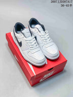 Pair of white and black Nike low-top sneakers displayed on a red Nike shoebox.