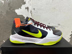 Side view of a Nike basketball shoe with a bright yellow-green Swoosh, dark side panel, and speckled white midsole.