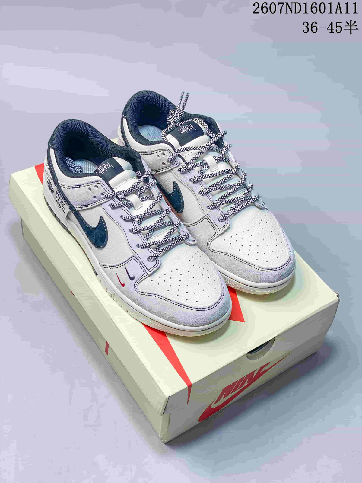 Pair of white and navy low-top sneakers displayed on a Nike shoe box, with style code 2607ND1601A11 and size range 36–45.5 visible above.