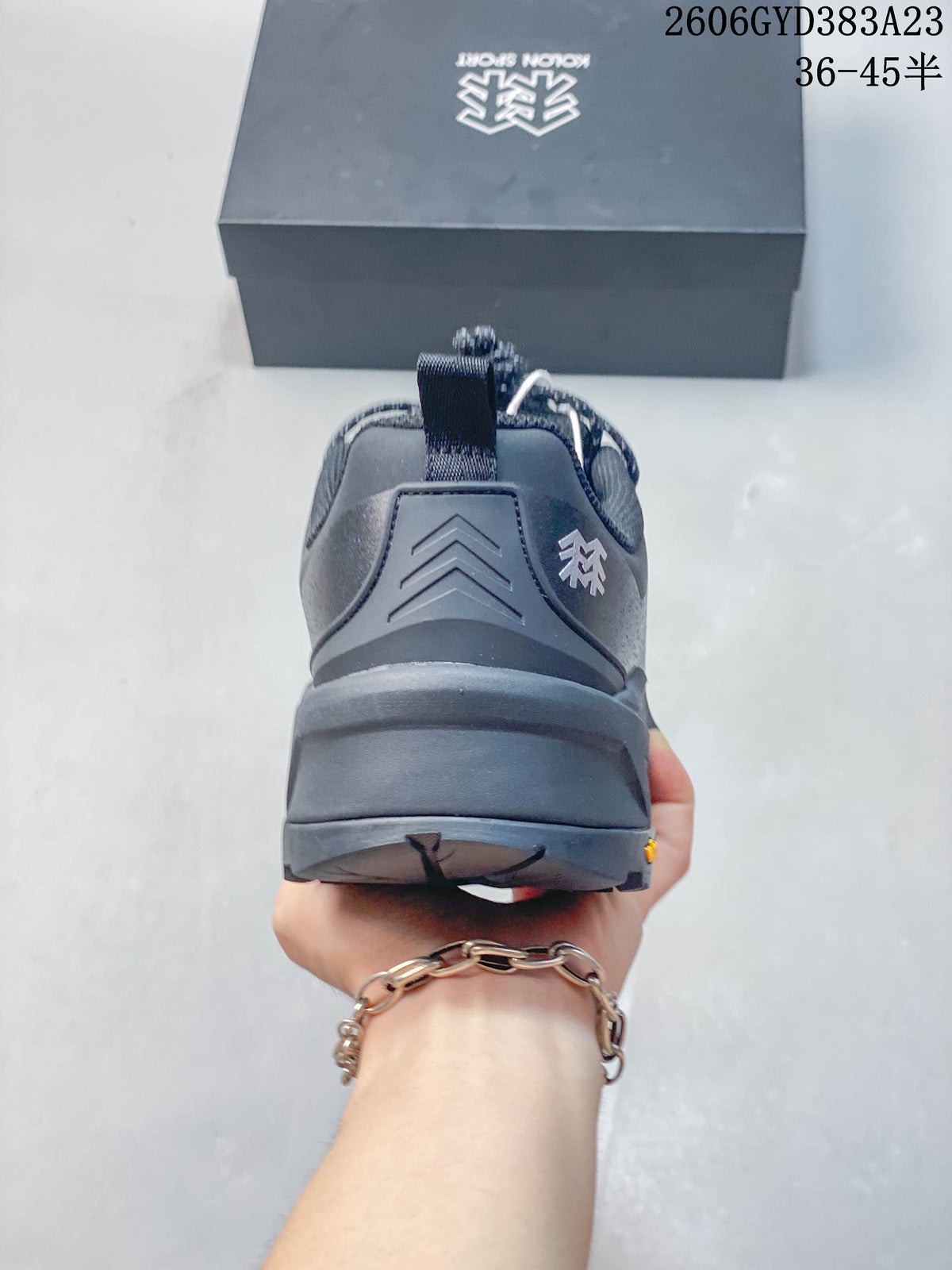 Rear view of the dark gray shoe showing heel structure and pull tab