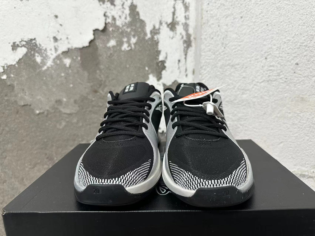 Front view of black and silver basketball shoes with lace-up fastening and patterned toe accents.