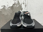 Front view of black and silver basketball shoes with lace-up fastening and patterned toe accents.