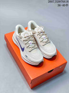 Pair of white and purple Nike Journey Run sneakers displayed on an orange shoebox.