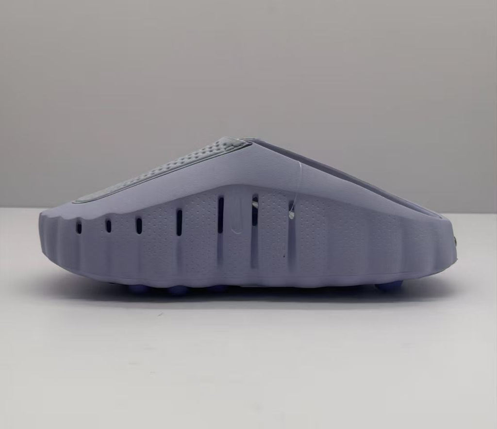 Lateral view of the purple slide showing vertical side vents and the raised outsole profile.