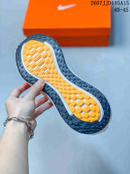 Close-up of the patterned rubber outsole with orange central tread and dark outer traction sections.