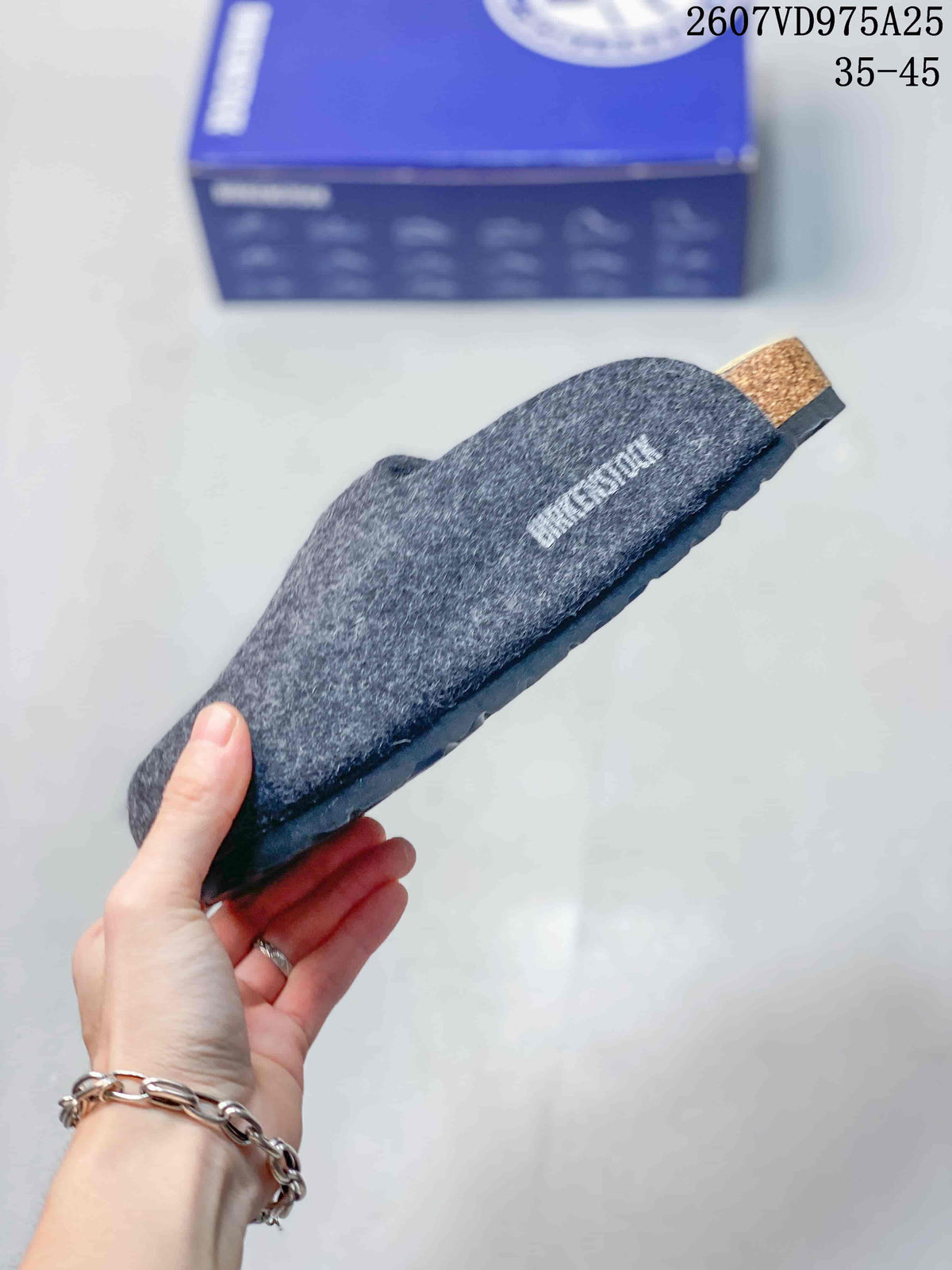 Side profile of the gray clog showing the closed upper, footbed area and outsole.