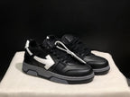 Three-quarter view of the black and white low-top sneaker pair with white lace accessories and gray layered midsoles.