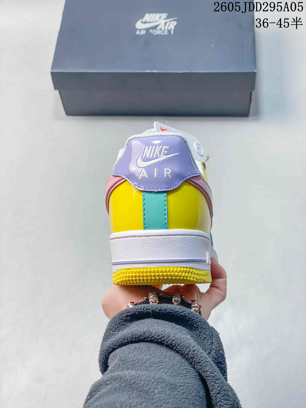Rear view of the multicolor sneaker showing the lavender heel tab, yellow and turquoise heel panels, white midsole and yellow outsole.