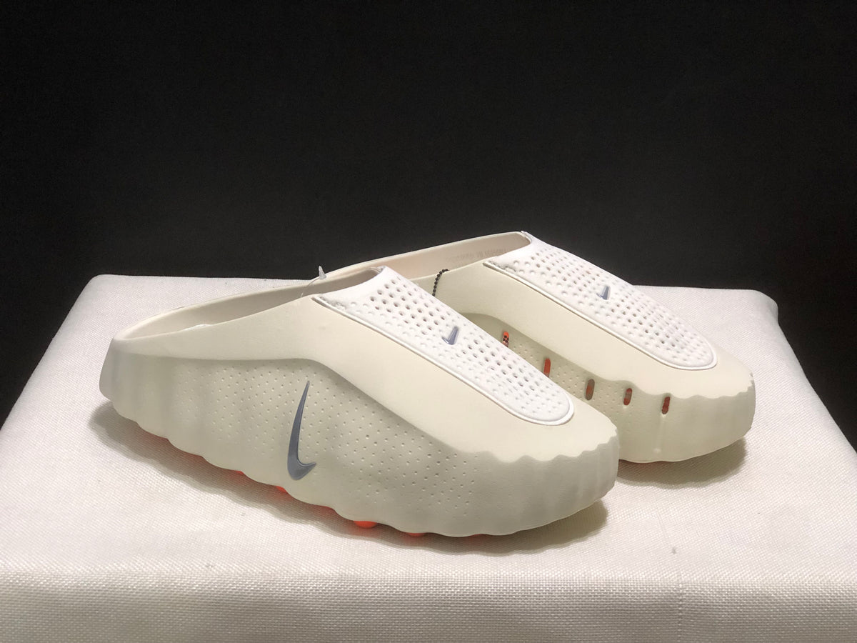 Three-quarter product view showing the light bone upper, grey Swoosh, and contrasting orange outsole details.