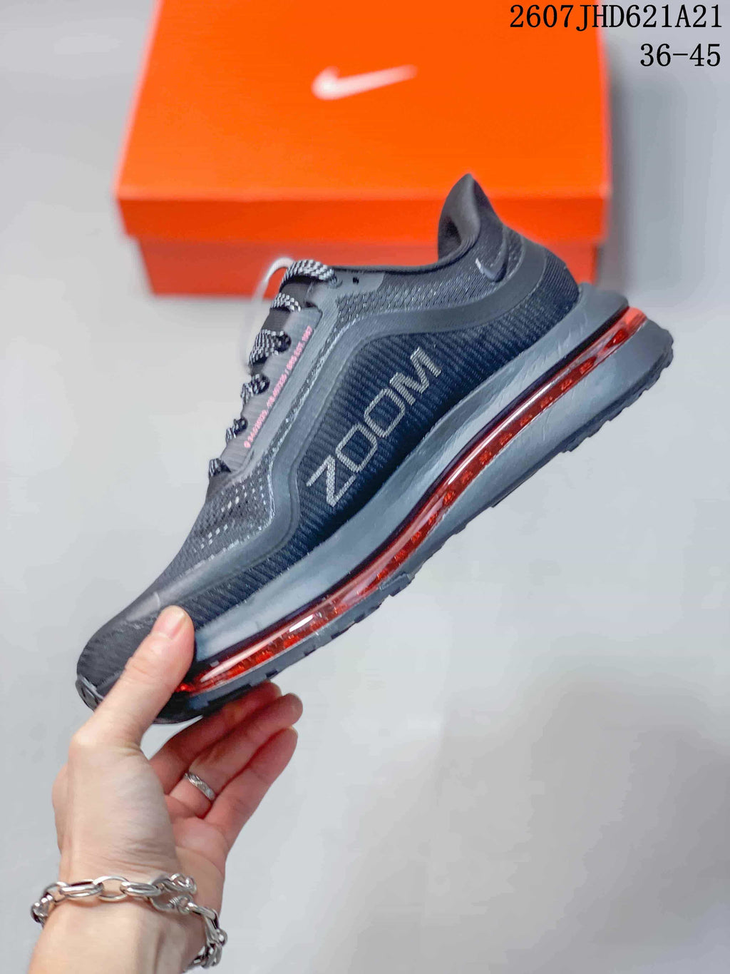 Side profile of the black and charcoal sneaker showing the Swoosh, textured upper, and red midsole detail.