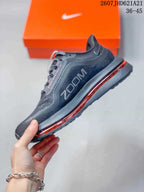 Side profile of the black and charcoal sneaker showing the Swoosh, textured upper, and red midsole detail.