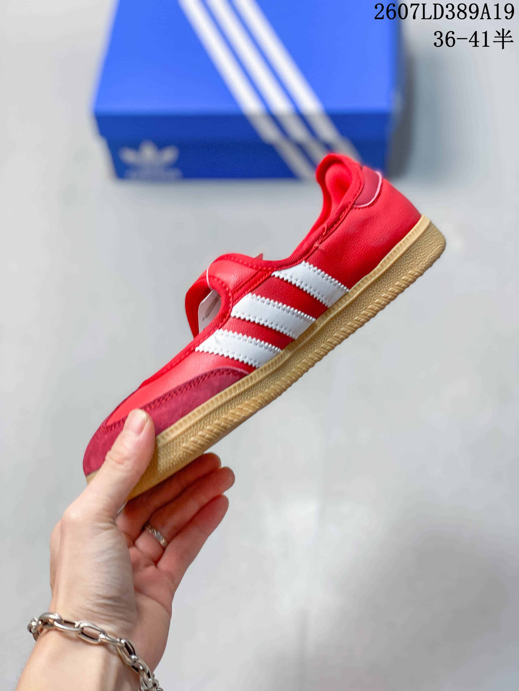 Side view of the red sneaker with white adidas stripes, a gum-colored outsole, and a low-profile silhouette.