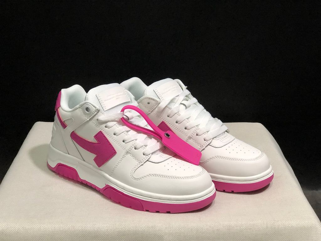 Three-quarter front view of the white and pink sneaker pair with the detachable pink tag accessory.