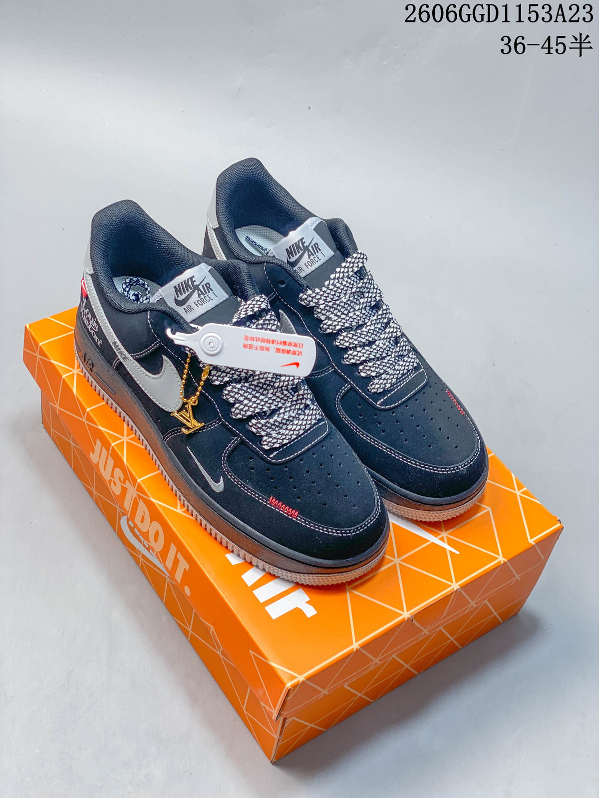 Pair of dark navy Nike Air Force 1 sneakers with gray accents, patterned laces, and a gold-tone charm