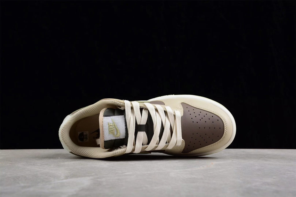 Top view showing the low-top shape, white laces, padded tongue, and brown perforated toe panel.