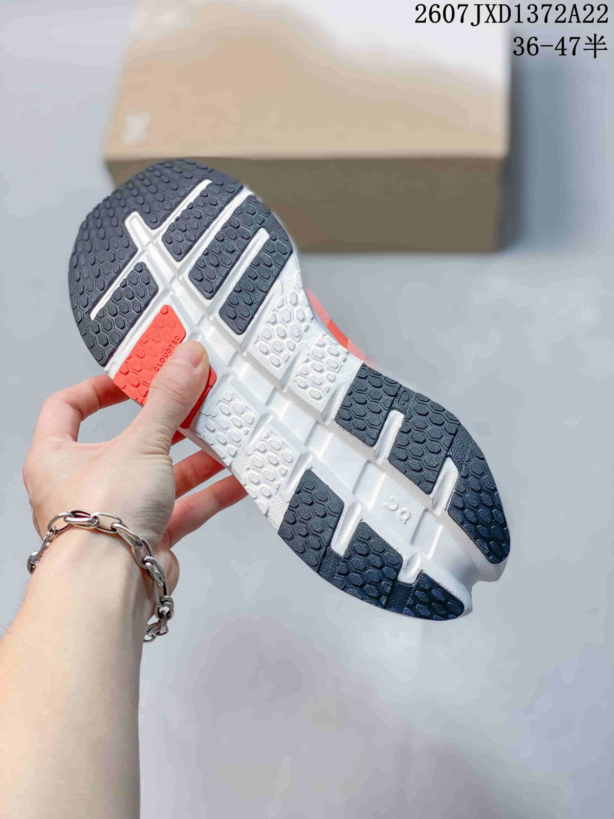 Bottom view of an On sneaker showing the segmented white and dark outsole tread pattern.