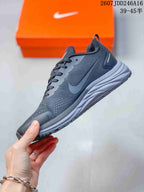 Side view of the dark Nike running shoe showing the swoosh, mesh-style upper, lace-up construction, and layered midsole.