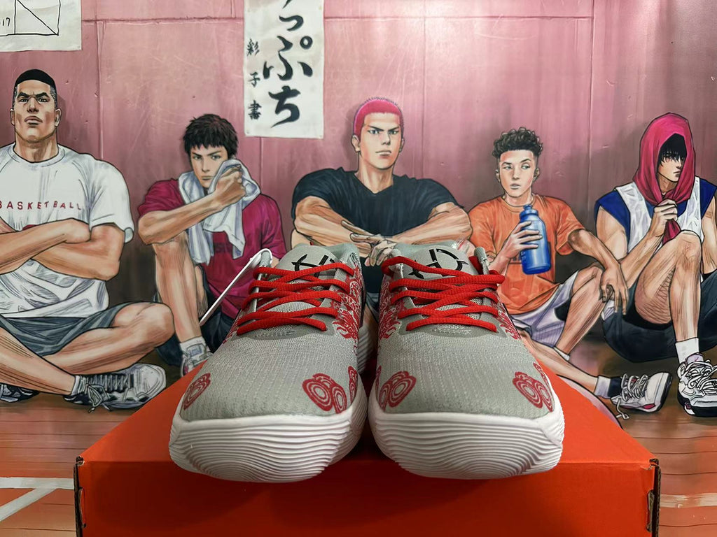 Front view of gray Nike sneakers with red laces and printed graphics.