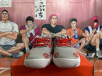 Front view of gray Nike sneakers with red laces and printed graphics.
