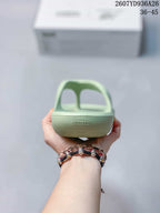 Rear view of the pale green sandal showing the open thong-style upper, heel area, and embossed branding.