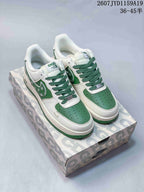 White and green Nike Air Force 1 '07 low sneakers with green laces and floral side detailing, displayed on a patterned shoebox.