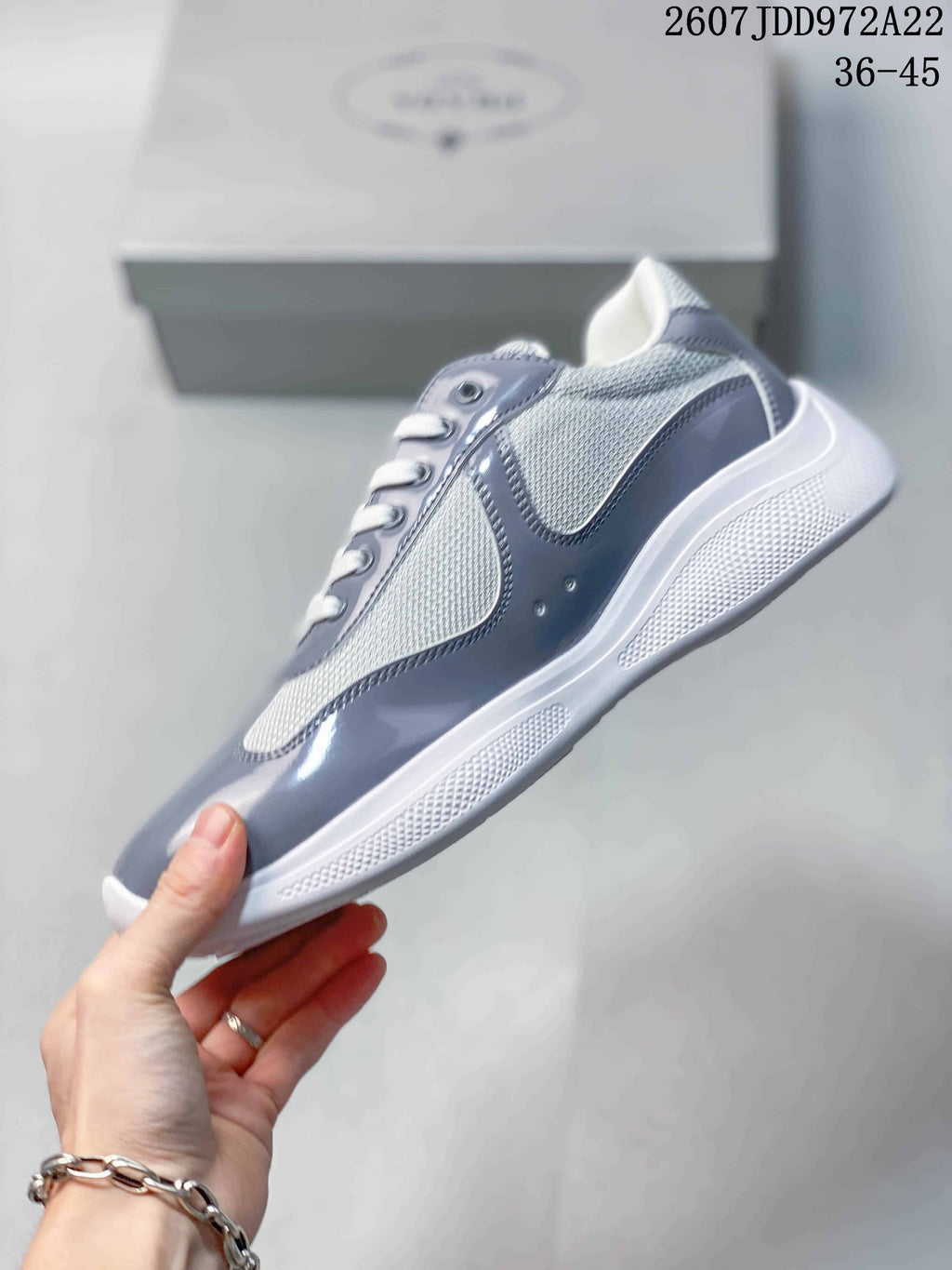 Side profile highlighting the gray glossy panels, white mesh sections, and textured white sole.