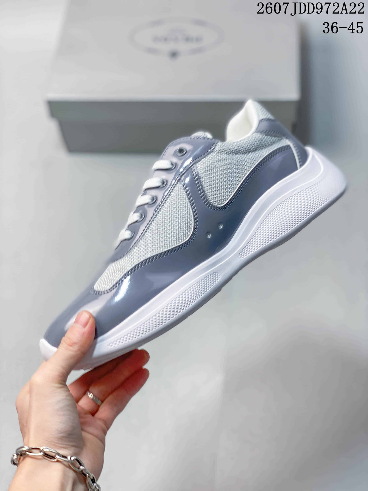 Side profile highlighting the gray glossy panels, white mesh sections, and textured white sole.