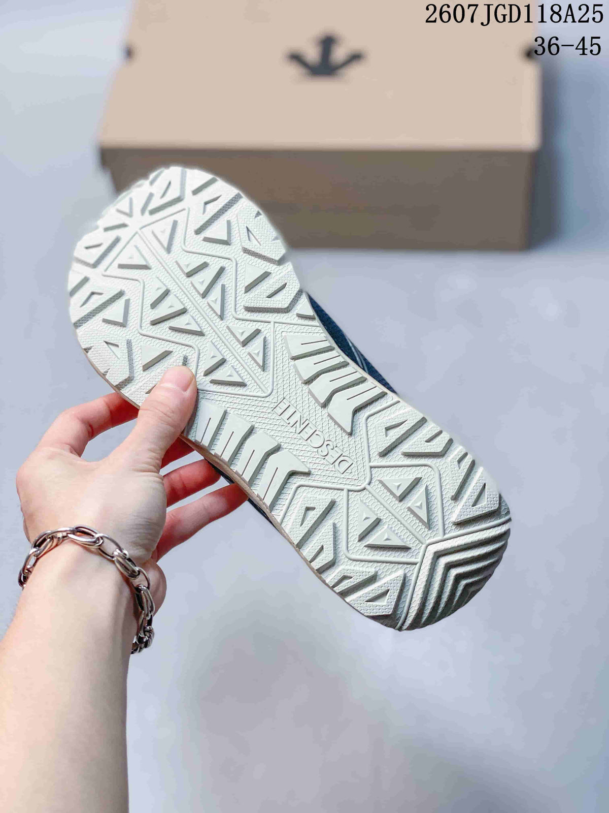 Close view of the sneaker outsole showing a raised geometric tread pattern and Descente branding.