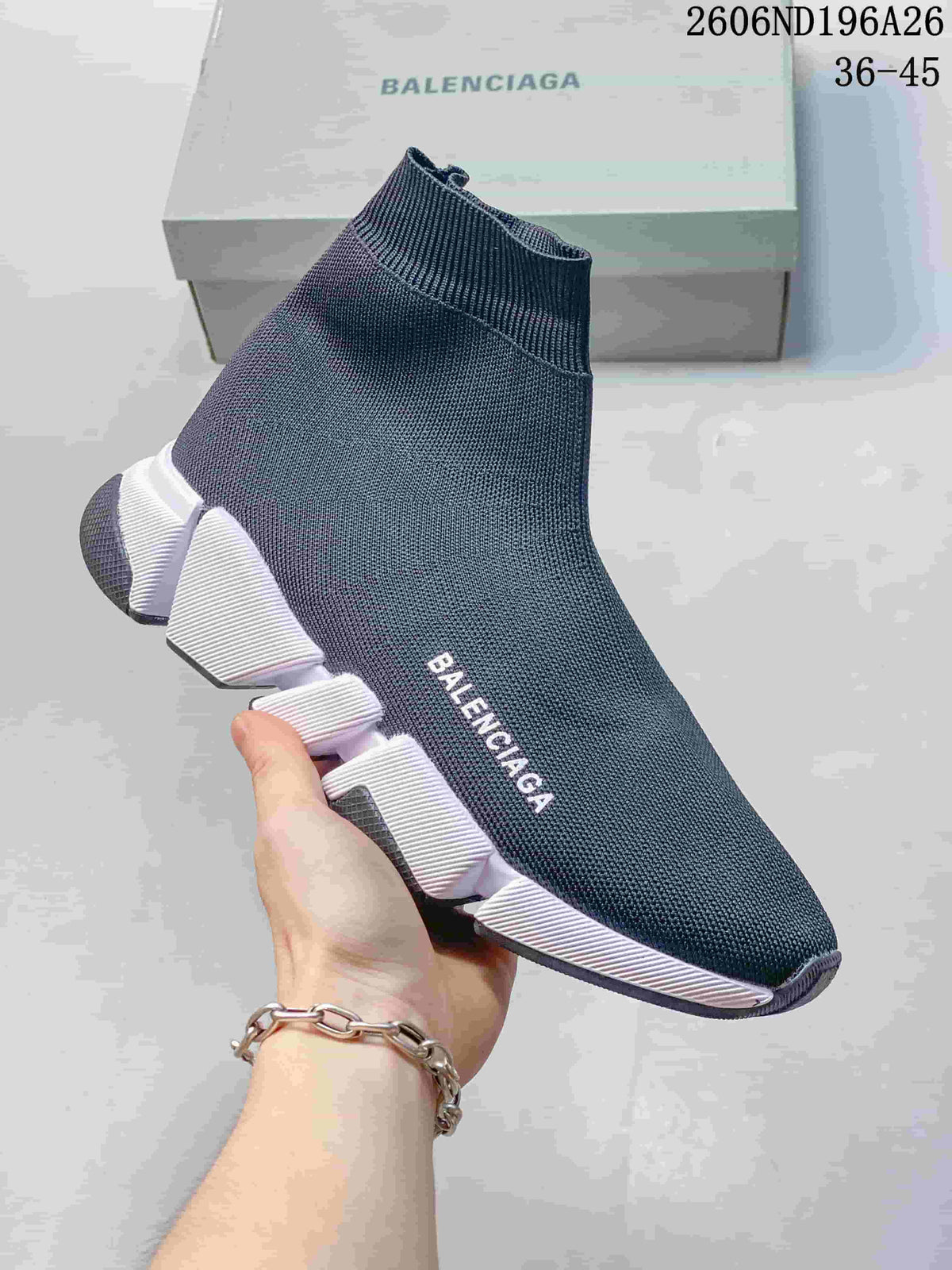 Side view of a dark knit sock-style sneaker with a segmented white sole.
