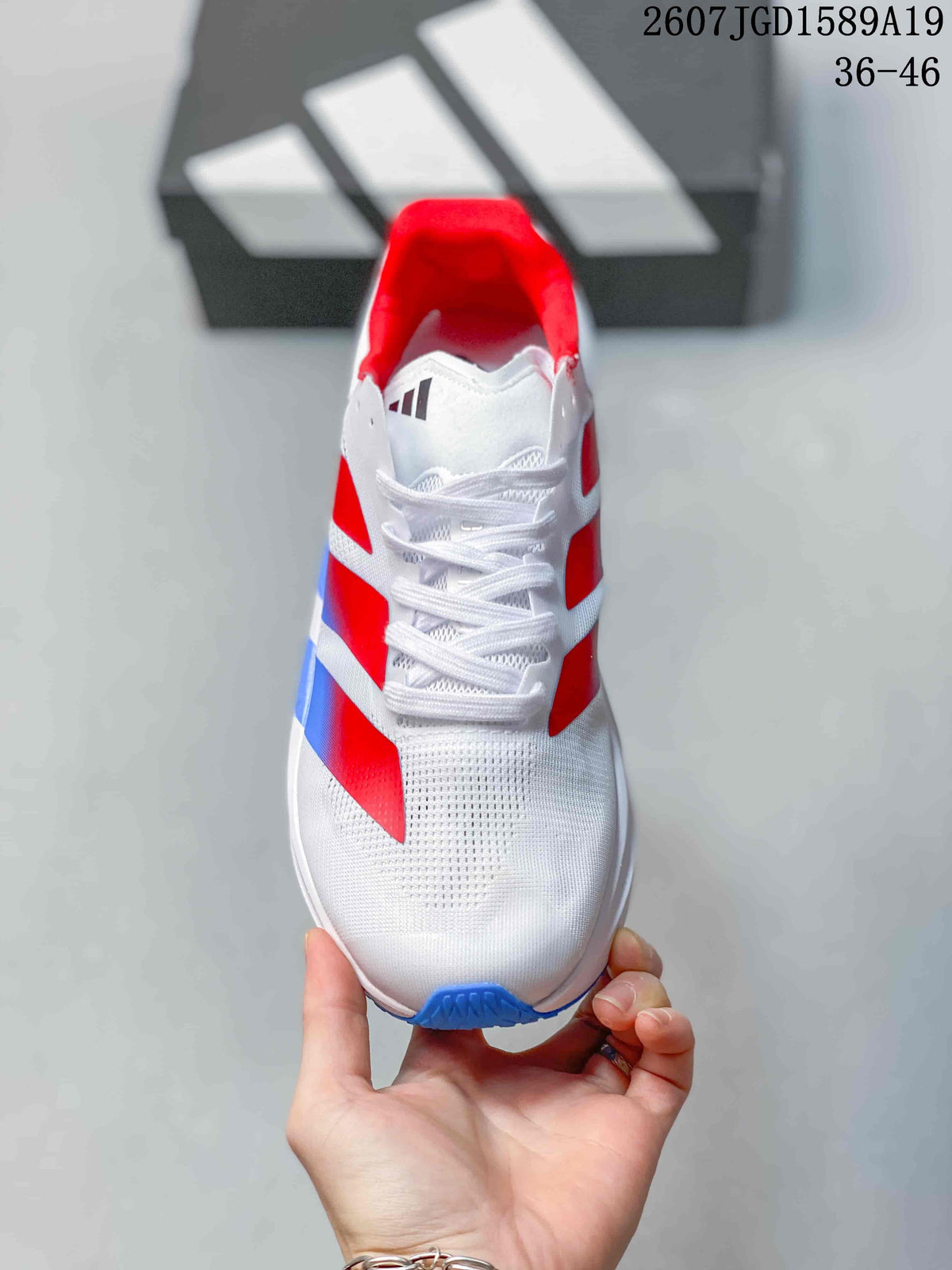 Top view of the sneaker showing the white lace-up front, perforated toe area, and red collar lining.