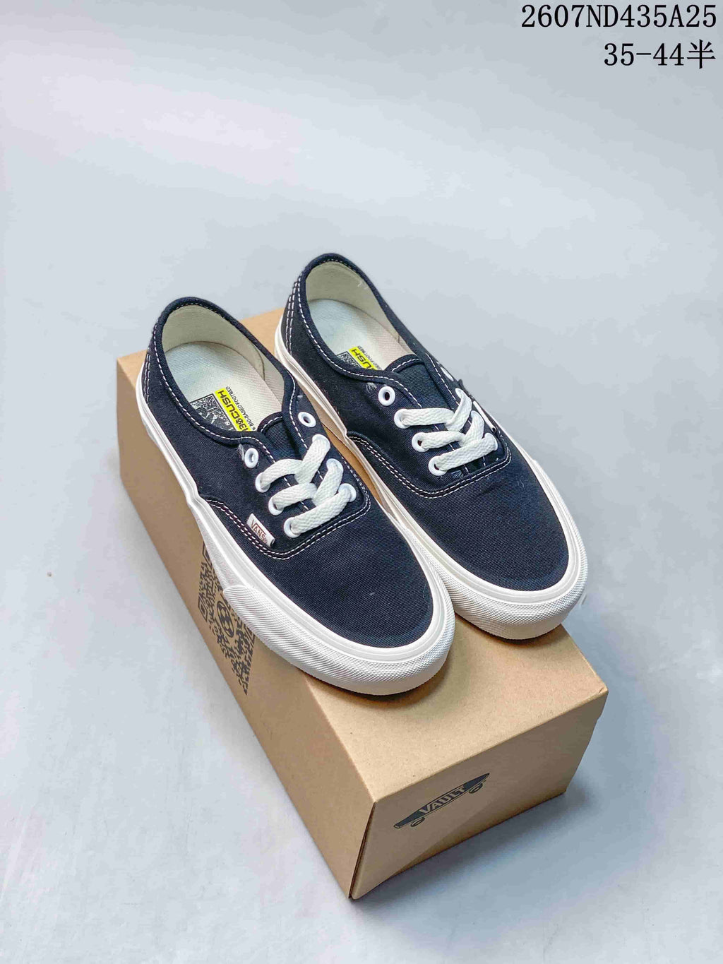 Pair of navy canvas lace-up low-top Vans sneakers with white laces and white sidewalls.