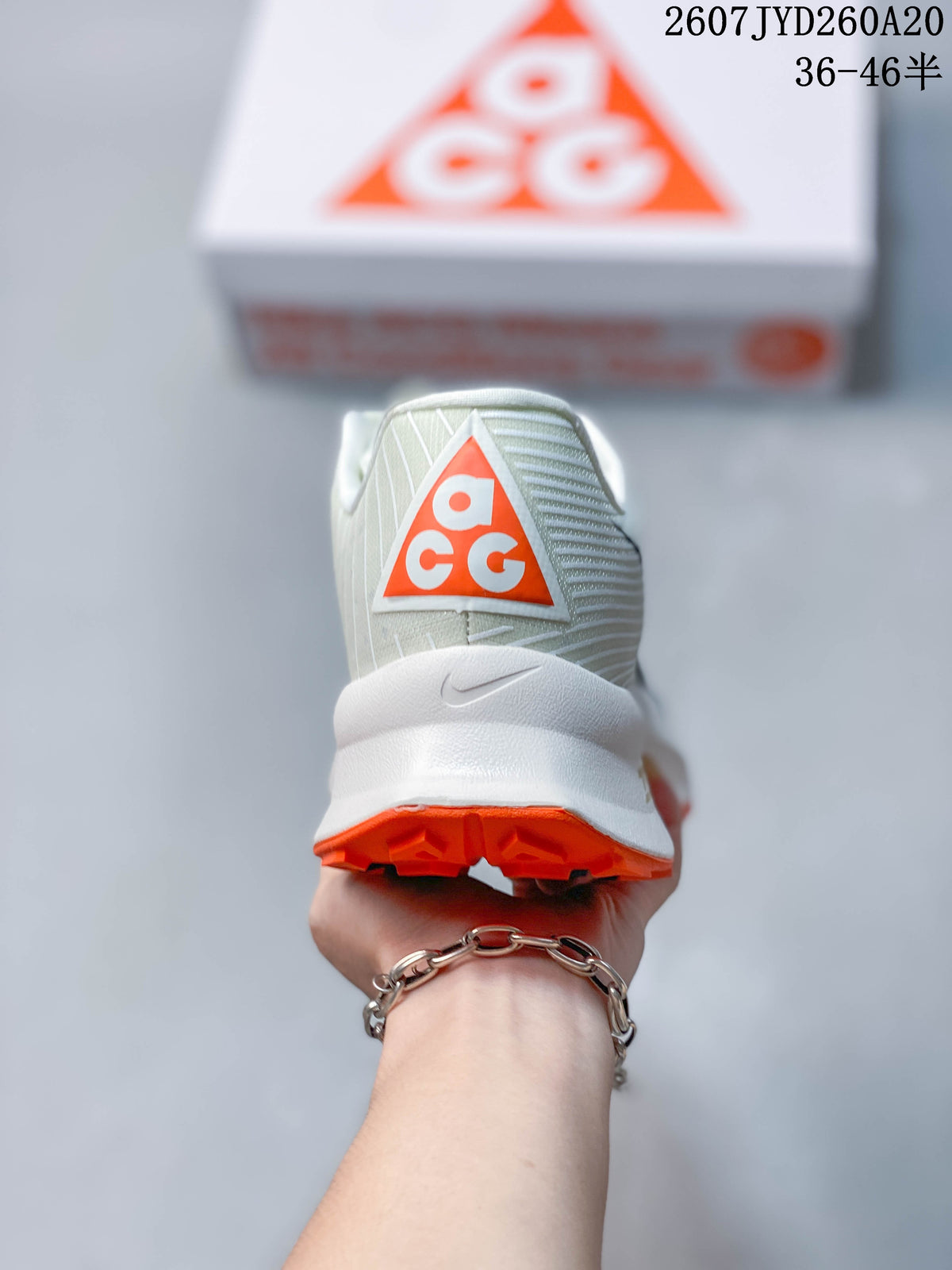 Rear view of an off-white Nike ACG Ultrafly Trail sneaker showing the ACG heel logo and orange outsole.