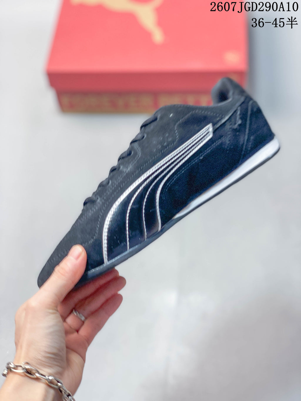 Side profile of the black low-top sneaker with white branding, lace eyelets, and a slim sole.