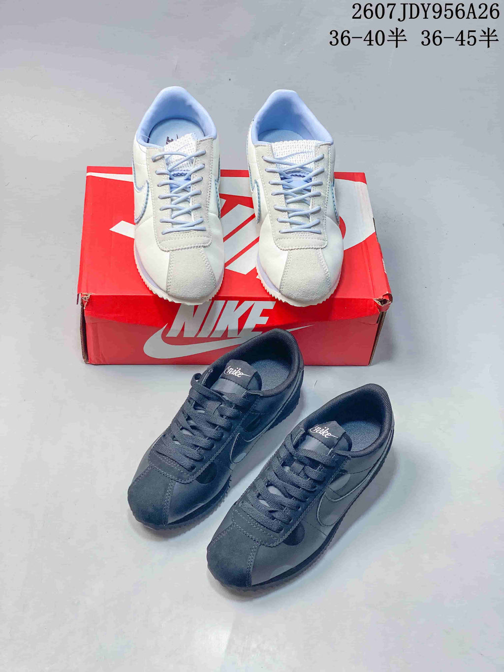 White and black Nike Classic Cortez sneakers shown together with a red Nike shoebox; overlay text shows style code 2607JDY956A26 and ranges 36–40.5 and 36–45.5.