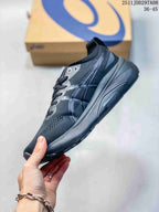 Side view of the dark gray ASICS sneaker showing the layered upper panels, lace area, and thick structured outsole.