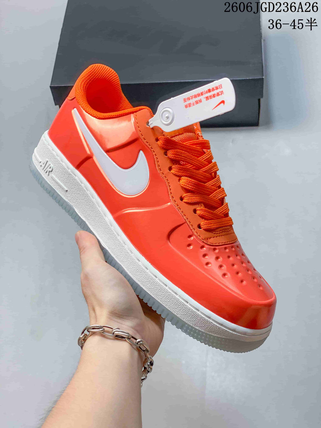 Angled view of the orange sneaker with white Swoosh and midsole