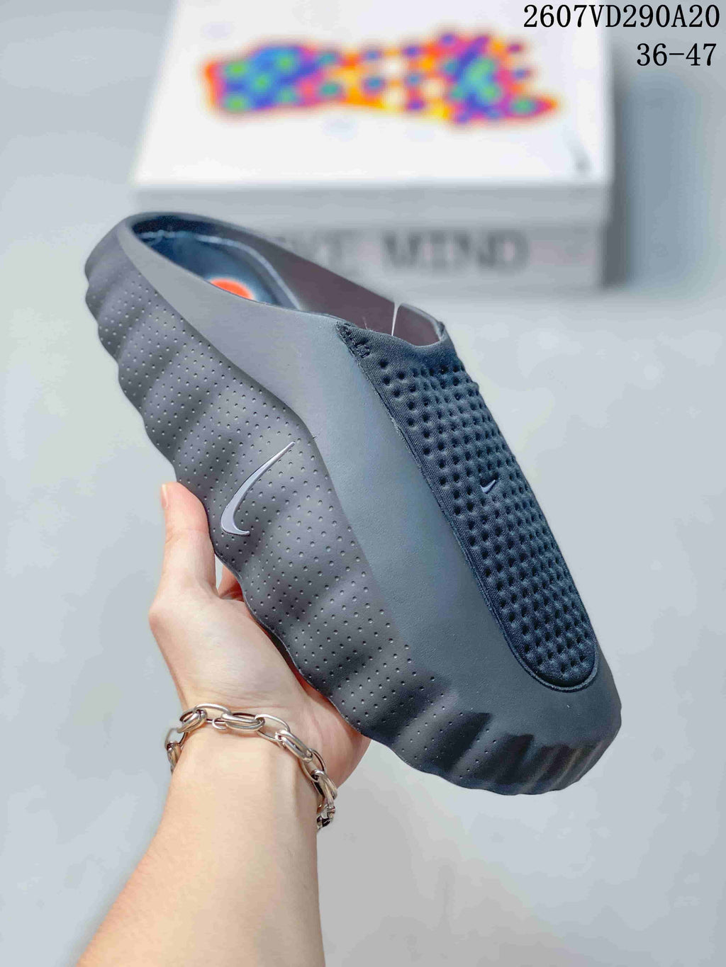 Angled side view of the slide showing the perforated upper, molded sole, and small side swoosh detail.