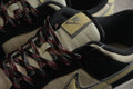 Close-up of the beige tongue, black collar, and red-and-black laces with a visible Nike tongue label.