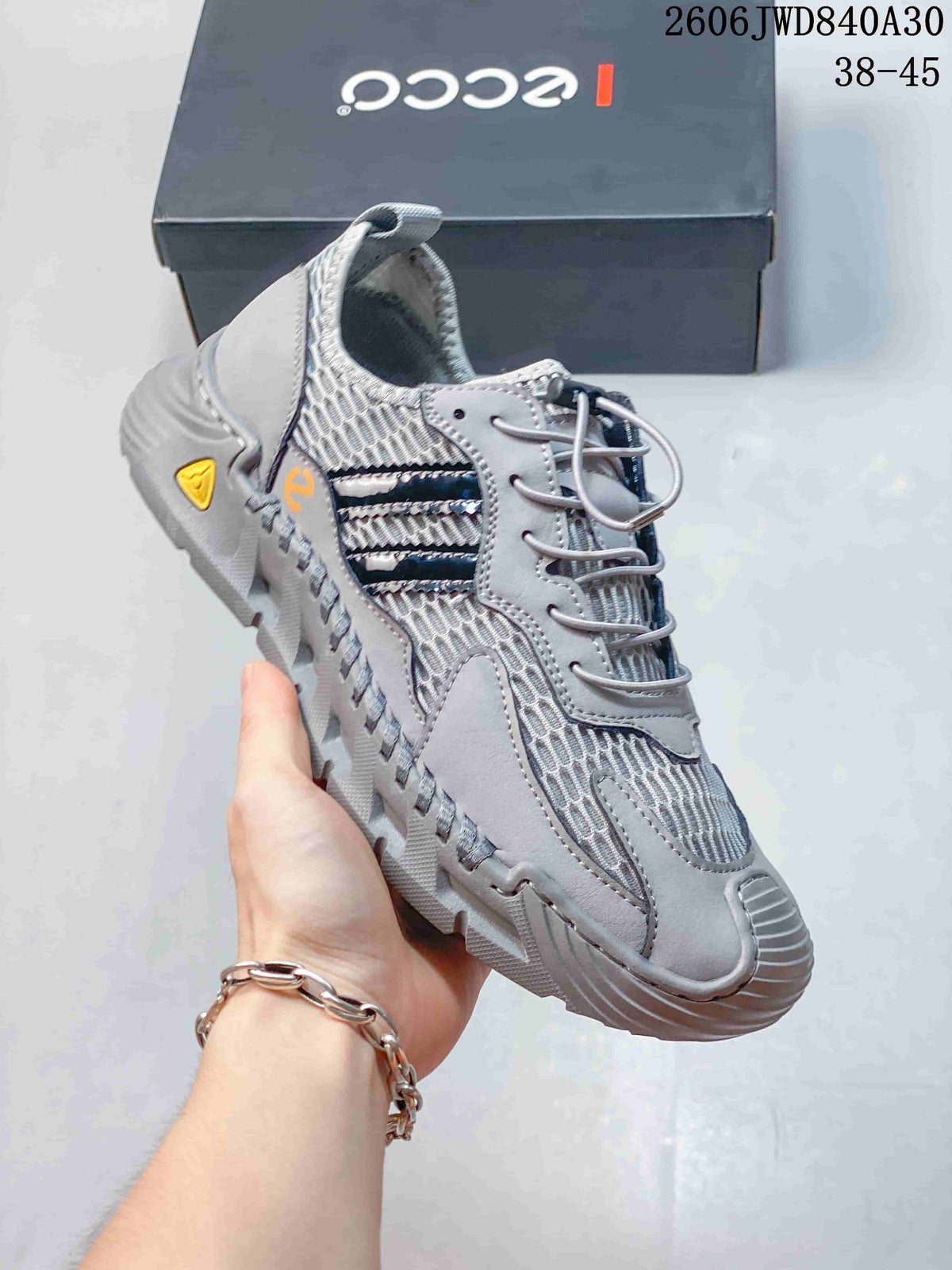 Angled side view of the gray sneaker with layered overlays