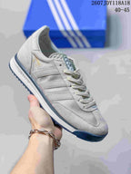 Light gray and white adidas SL 72 sneaker with subtle gold branding and a dark blue outsole.