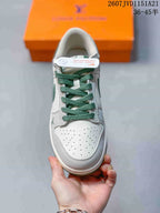 Top view of one sneaker showing the perforated white toe box, green laces, and padded collar.