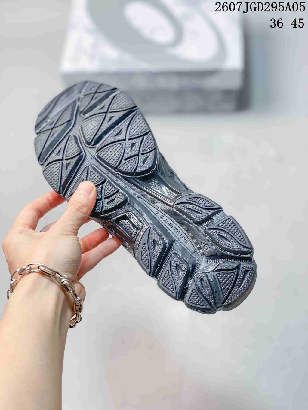 Close view of the segmented patterned outsole on a dark sneaker.